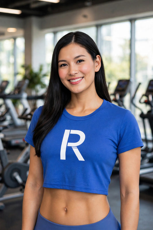 Athletic model in a blue Ripped City crop tee with white R centered, gym scene