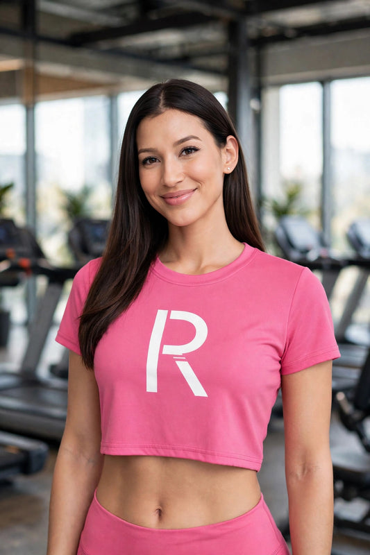 Athletic model in a pink Ripped City crop tee with white R centered, gym scene