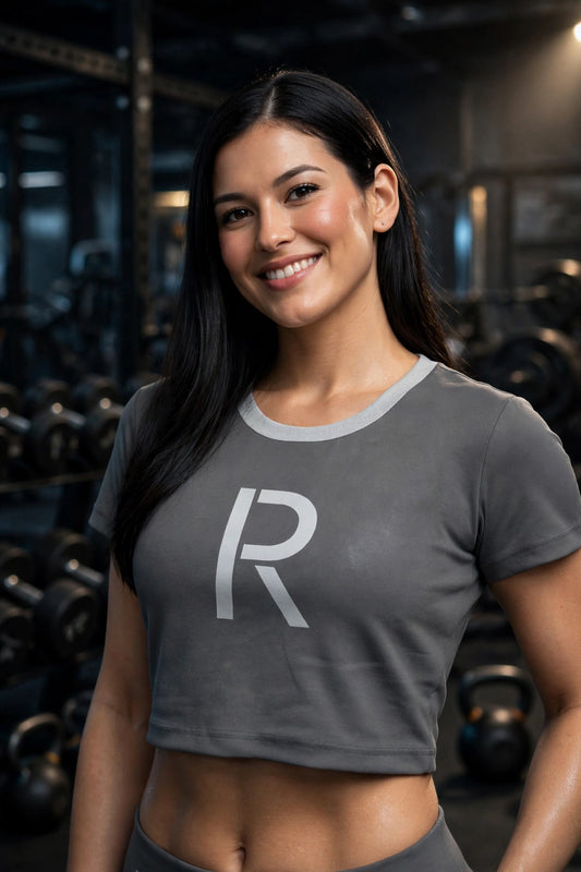 Athletic model in a gray Ripped City crop tee with white R centered, gym scene