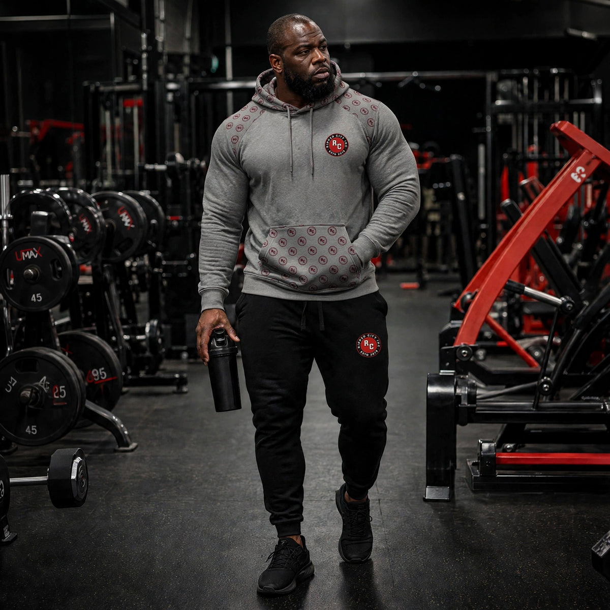 Unisex grey training hoodie with RC badge, worn by athletic model in gym