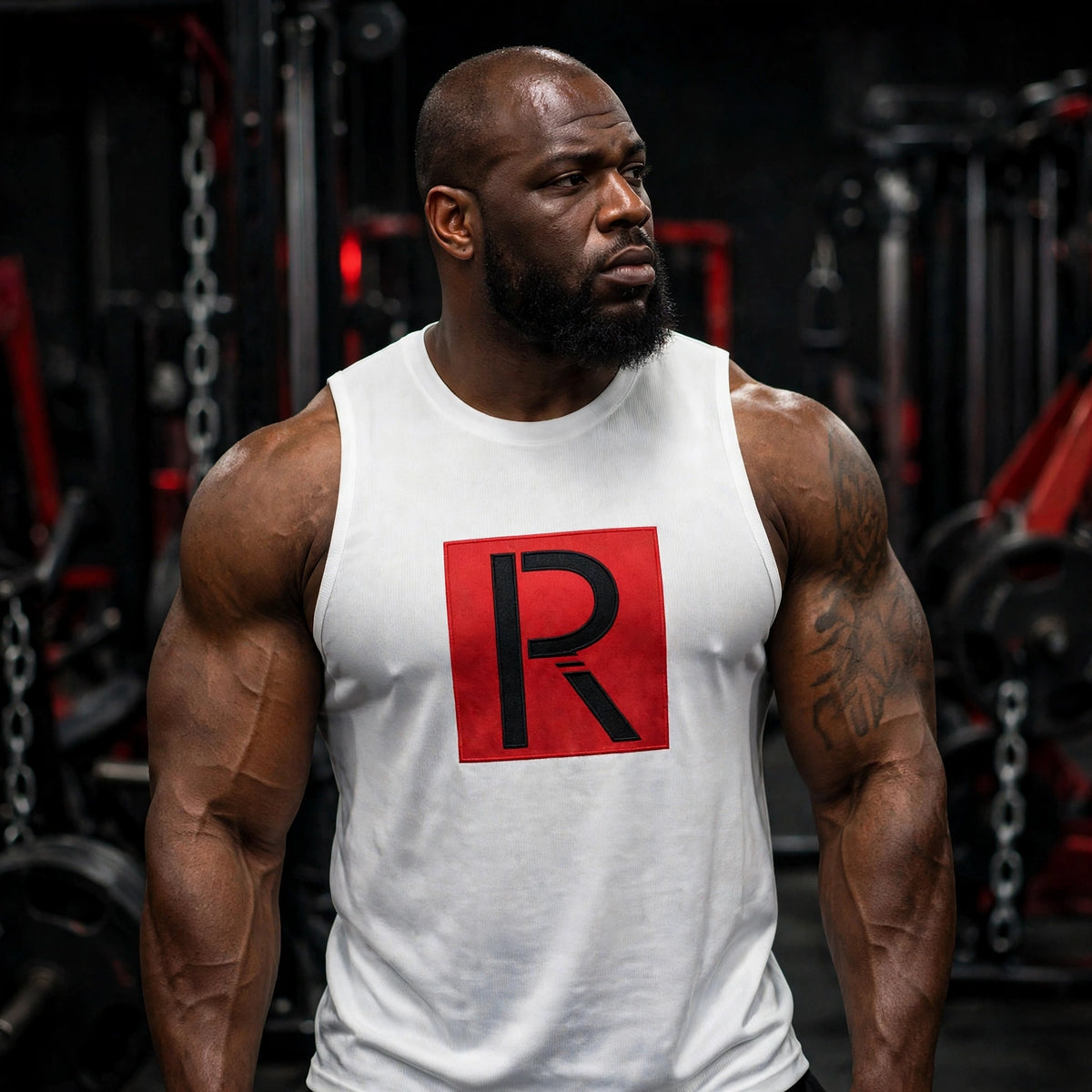 White muscle tank with black Ripped City R in red square, worn by athletic model in gym