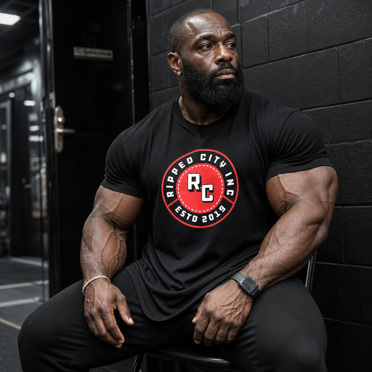 Muscular bodybuilder wearing the Ripped City men's gym logo T-shirt during strength training - Ripped City Inc premium gym apparel