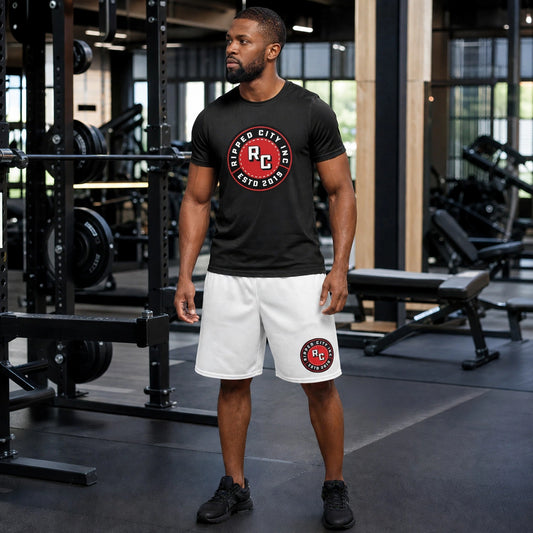 Athletic model in a black Ripped City tee and white shorts with red RC badge, gym scene